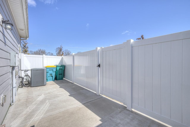 view of patio with central AC and fence