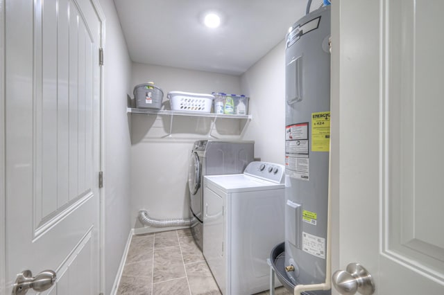 laundry room featuring laundry area, baseboards, washer and dryer, and electric water heater