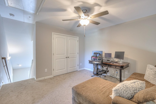 office area with carpet floors, attic access, baseboards, and ceiling fan