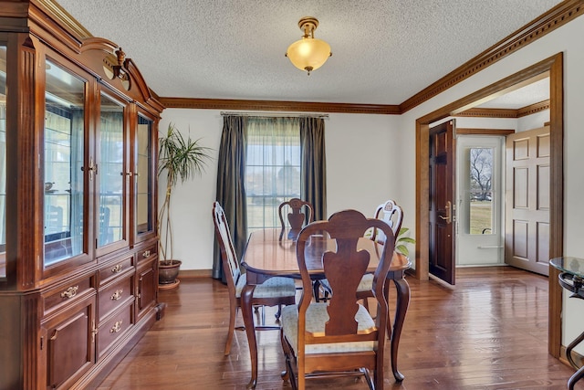 dining room with baseboards, ornamental molding, dark wood finished floors, and a textured ceiling