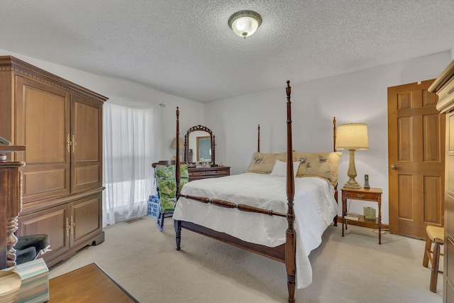 bedroom featuring light carpet, a textured ceiling, and visible vents