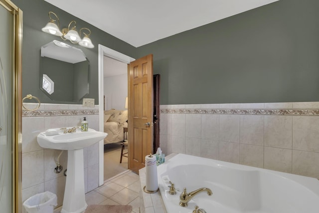 bathroom with tile patterned flooring, tile walls, a bath, and wainscoting