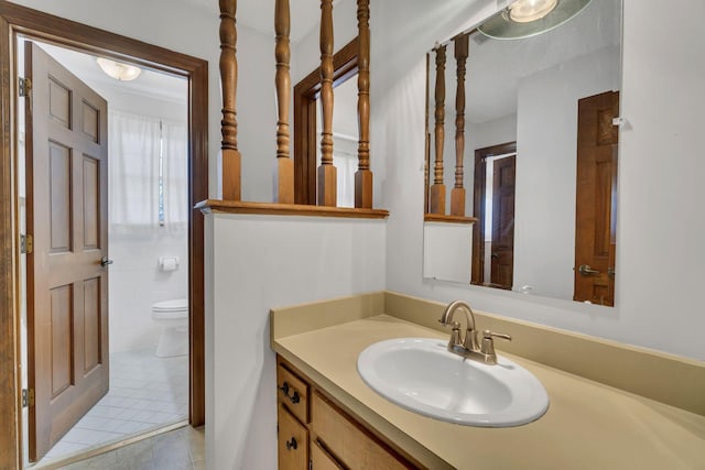 bathroom with tile patterned flooring, tile walls, vanity, and toilet