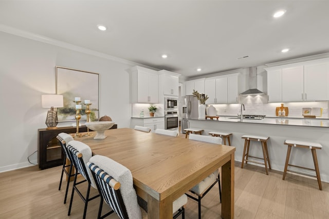 dining space with light wood-style floors, baseboards, ornamental molding, and recessed lighting