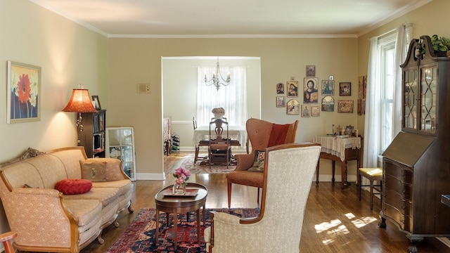 living room featuring baseboards, dark wood-type flooring, ornamental molding, and a notable chandelier