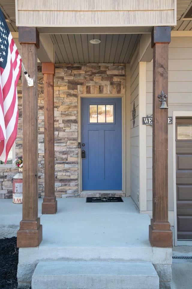 entrance to property with a garage and stone siding