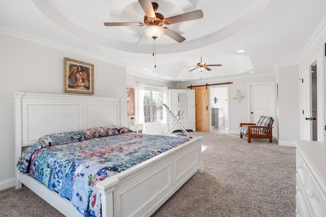 bedroom with a raised ceiling, light colored carpet, a barn door, ornamental molding, and baseboards