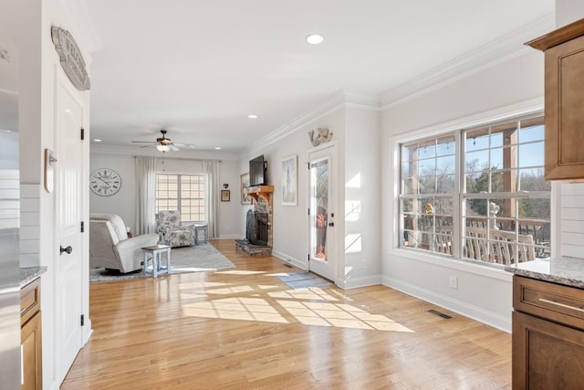 entrance foyer featuring light wood-type flooring, baseboards, visible vents, and crown molding