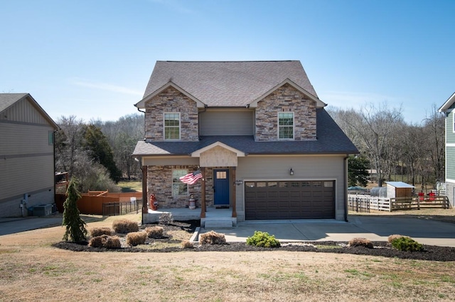 view of front of house with a garage, a shingled roof, fence, stone siding, and concrete driveway