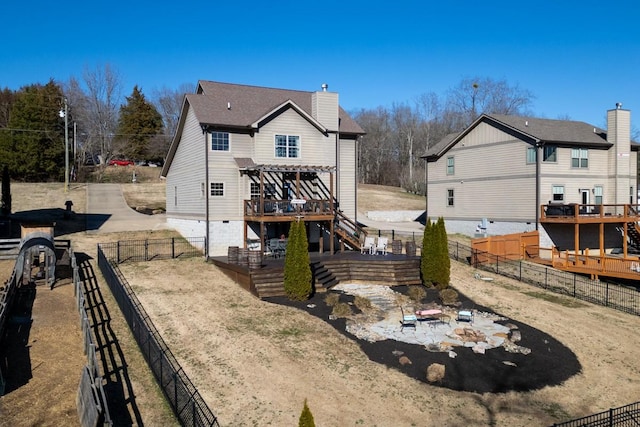 rear view of house with a patio, a fenced backyard, a chimney, stairway, and a deck