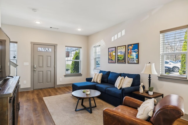 living area with visible vents, baseboards, dark wood finished floors, and recessed lighting