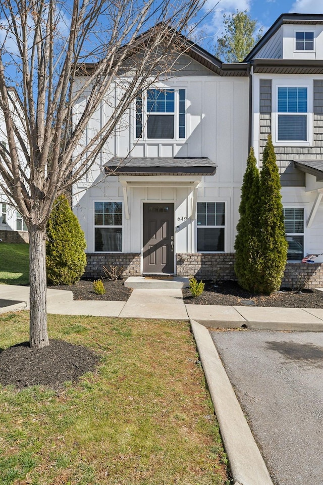 townhome / multi-family property featuring board and batten siding and a front yard