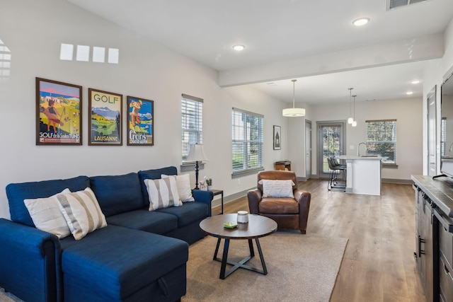 living area featuring baseboards, wood finished floors, and recessed lighting