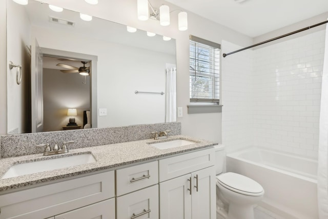 bathroom with toilet, double vanity, visible vents, and a sink