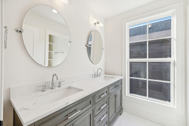 full bath featuring double vanity, a sink, and tile patterned floors