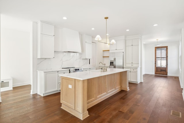 kitchen featuring dark wood-style flooring, a sink, appliances with stainless steel finishes, custom exhaust hood, and tasteful backsplash