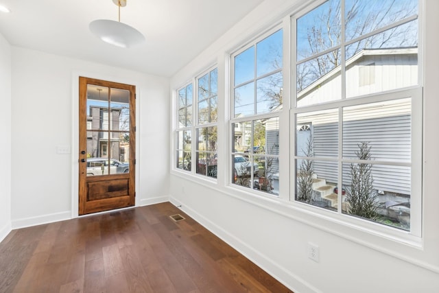 doorway to outside featuring visible vents, baseboards, and dark wood-style flooring