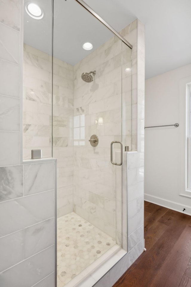 full bathroom featuring a stall shower and wood finished floors