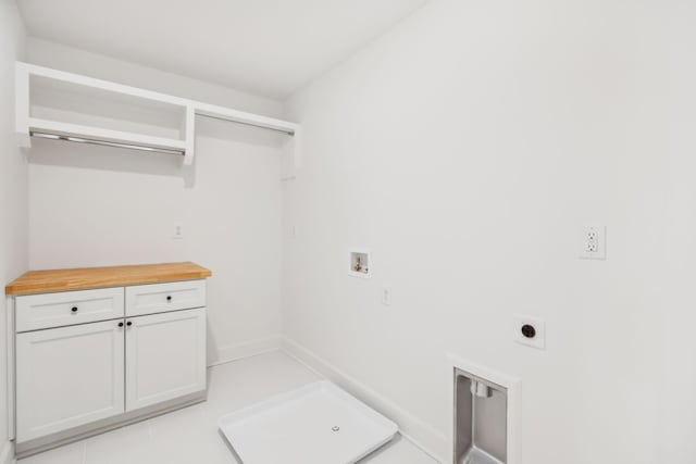 laundry area with light tile patterned floors, washer hookup, baseboards, cabinet space, and electric dryer hookup