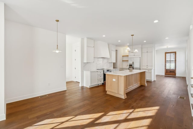 kitchen with stainless steel appliances, light countertops, backsplash, dark wood-style floors, and custom range hood