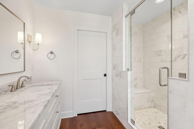 bathroom featuring wood finished floors, vanity, and a shower stall