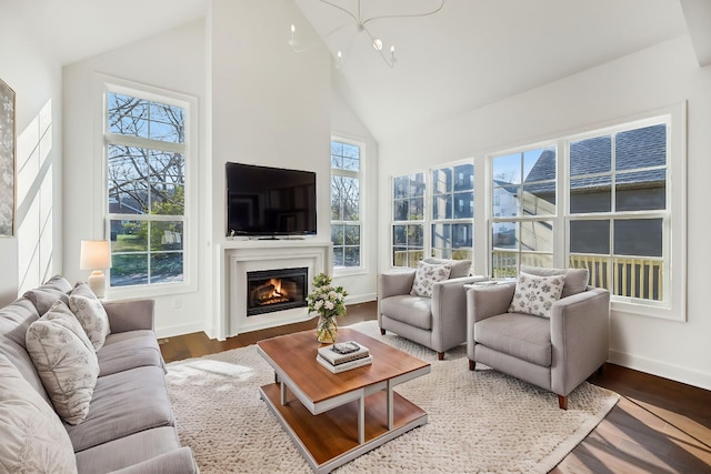 sunroom with a healthy amount of sunlight, vaulted ceiling, and a glass covered fireplace