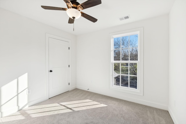 unfurnished bedroom featuring baseboards, visible vents, a ceiling fan, and light colored carpet