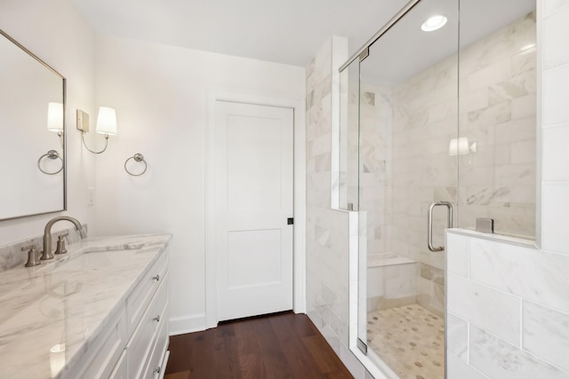 bathroom featuring a stall shower, vanity, and wood finished floors