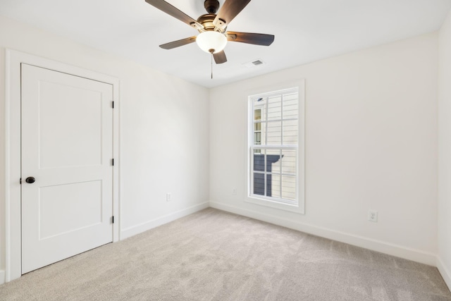 empty room featuring visible vents, baseboards, ceiling fan, and carpet flooring