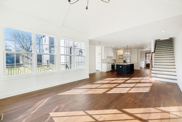 unfurnished living room with recessed lighting, dark wood-type flooring, visible vents, baseboards, and stairway