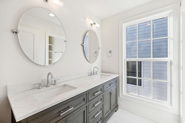 full bathroom with double vanity, a sink, and tile patterned floors