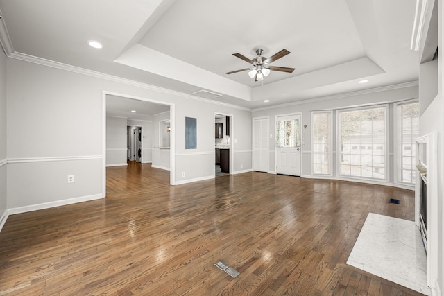 unfurnished living room featuring a raised ceiling, baseboards, and hardwood / wood-style floors