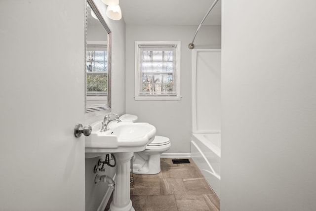 bathroom with visible vents, tub / shower combination, toilet, and baseboards