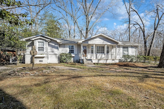 view of front of house with a shingled roof, crawl space, covered porch, and a front lawn