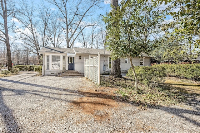 view of front of house with crawl space and gravel driveway