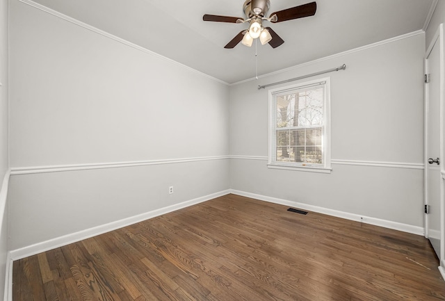 spare room featuring crown molding, wood finished floors, visible vents, and baseboards