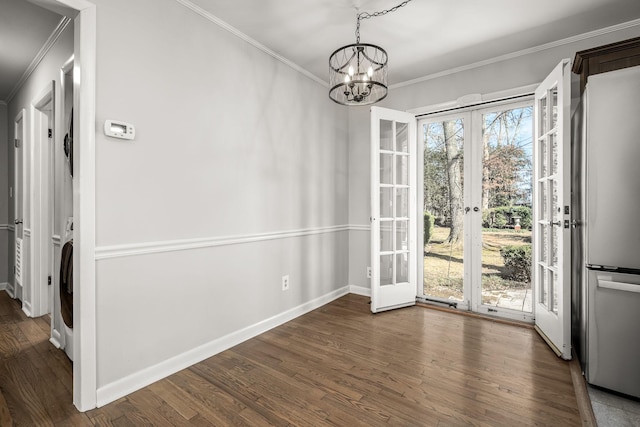 unfurnished dining area with ornamental molding, french doors, and dark wood finished floors