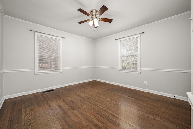 empty room with ornamental molding, dark wood-style flooring, and visible vents