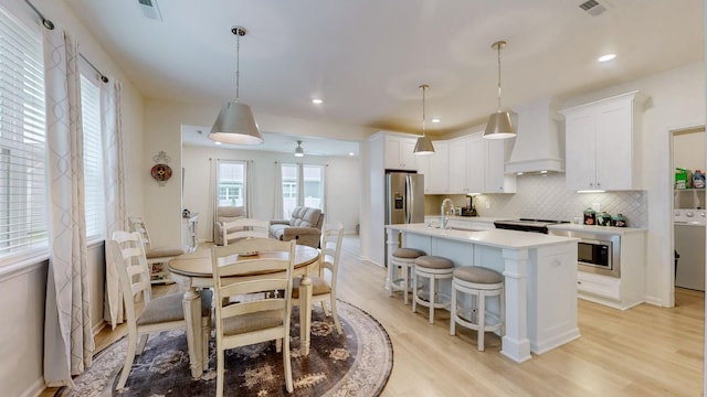 dining area with light wood-type flooring, visible vents, and recessed lighting