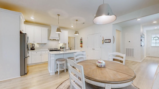 dining space with light wood-style floors, visible vents, and recessed lighting