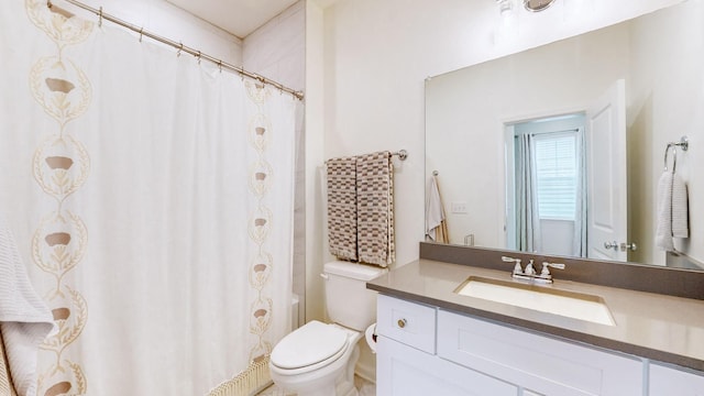 bathroom with curtained shower, vanity, and toilet