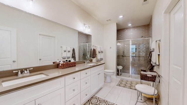 bathroom with a stall shower, a sink, toilet, and double vanity