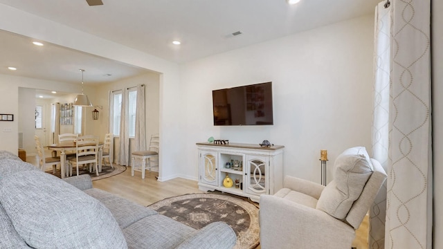 living area with baseboards, wood finished floors, visible vents, and recessed lighting