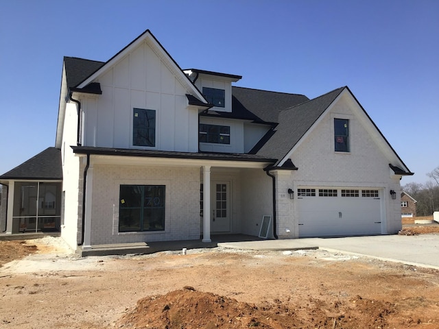 view of front of house with board and batten siding, an attached garage, and a sunroom