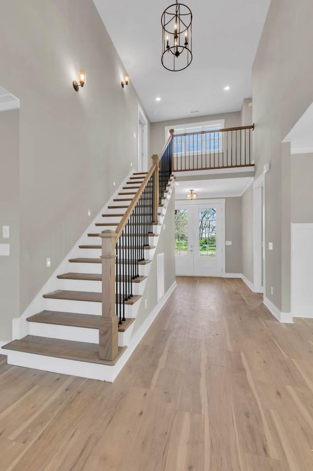 919 Licinius Ln, Murfreesboro, TN 37128 - stairway featuring baseboards, a notable chandelier, recessed lighting, wood finished floors, and a towering ceiling