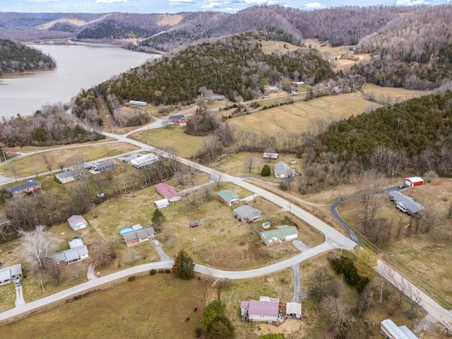 drone / aerial view featuring a water view and a wooded view