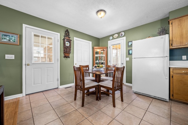 dining area with light tile patterned floors, baseboards, and a wealth of natural light