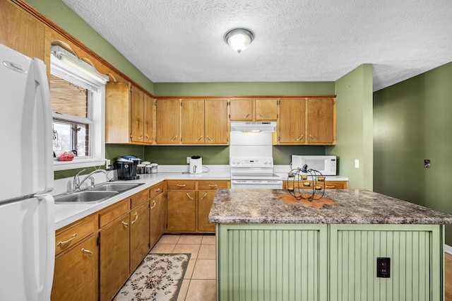 kitchen featuring light tile patterned floors, under cabinet range hood, white appliances, a sink, and a center island