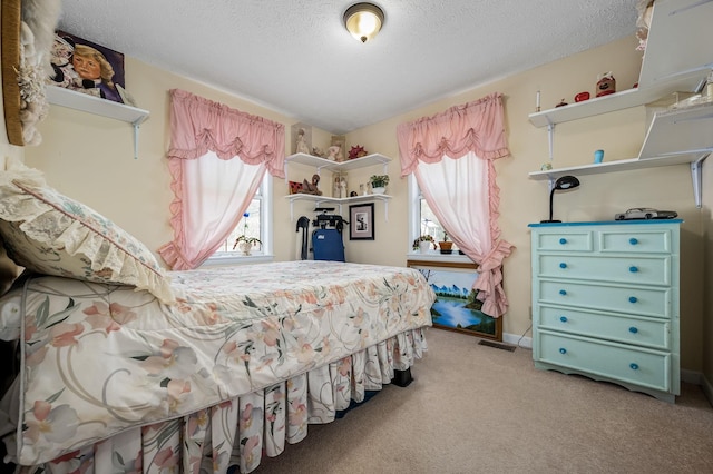 bedroom with carpet floors, multiple windows, visible vents, and a textured ceiling