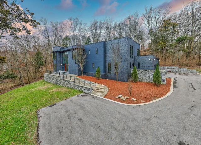 contemporary house with driveway and a front lawn